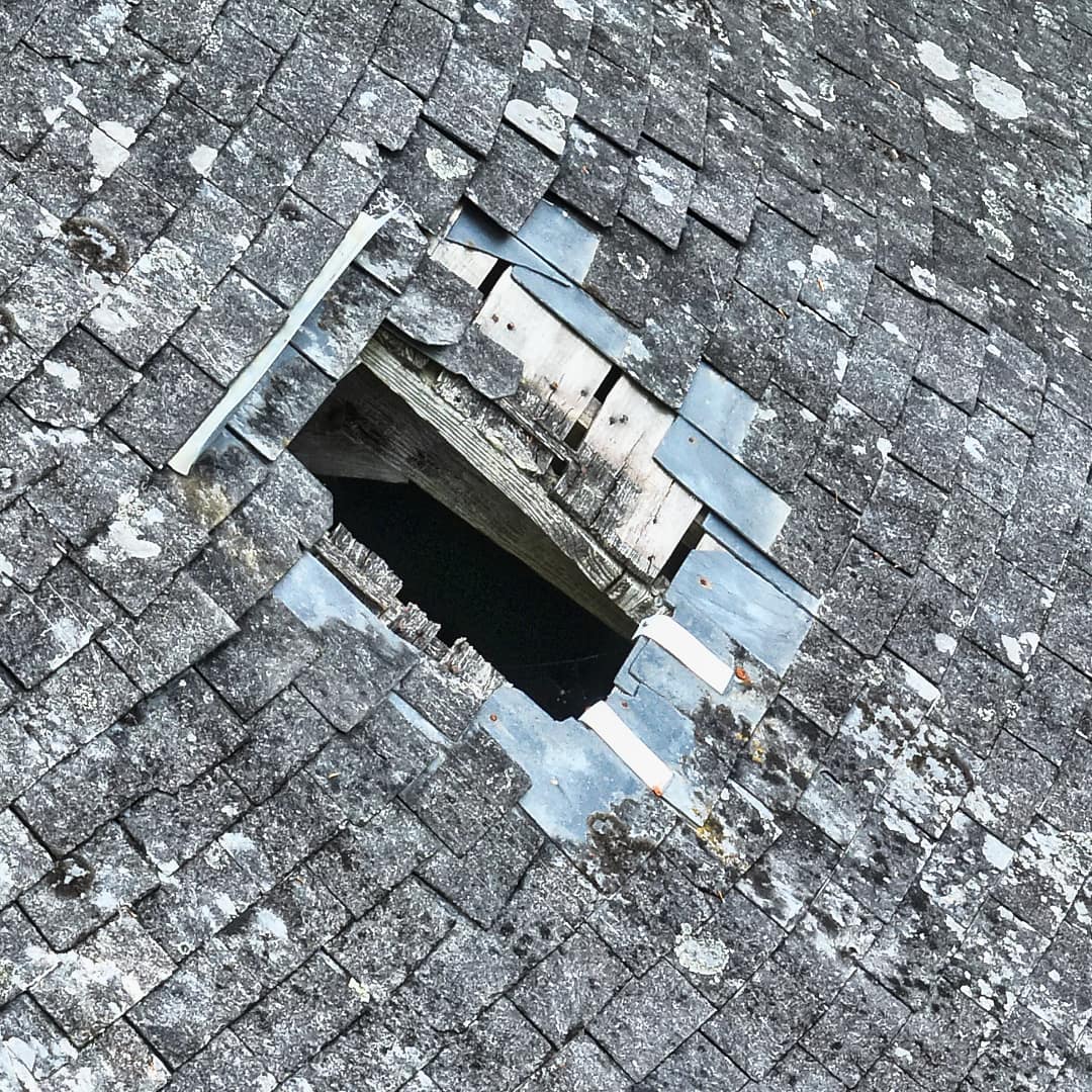 Fenêtre arrachée dans une toiture suite à une tempête